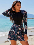 2026 Women's Exotic Swimdress: Navy Blue Tropical Leaf Print Long-Sleeve One-Piece With Solid Black Chest Panel And Front Half-Zip